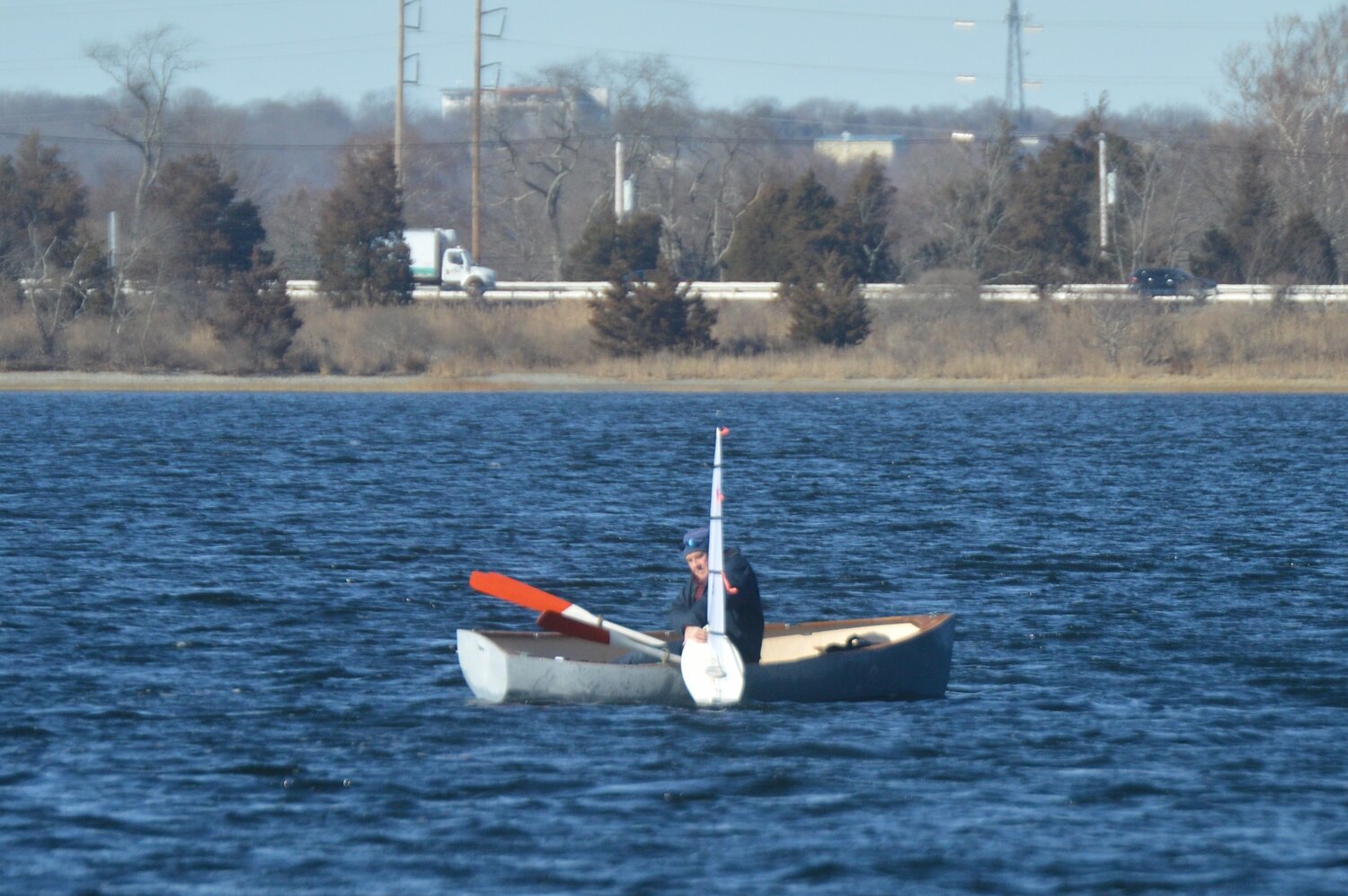 Rick Bassler grabs a boat that drifted outside the range of its racer’s remote control.