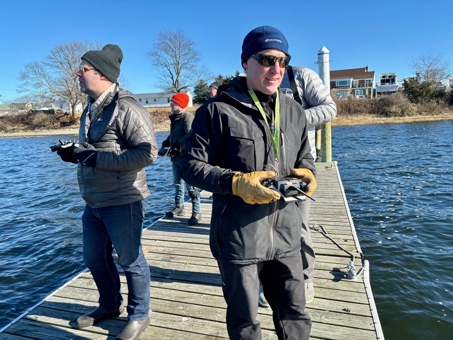 Jon Buonaccorsi (left) and Mike Sarnowski work their controls while guiding their model sailboats at the end of the pier behind Sunset Cove on Sunday.