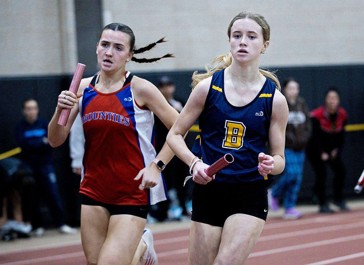 The Barrington High School girls indoor track team finished third at the Class Championship meet. Here, a Barrington runner (right) competes in the division championship meet.