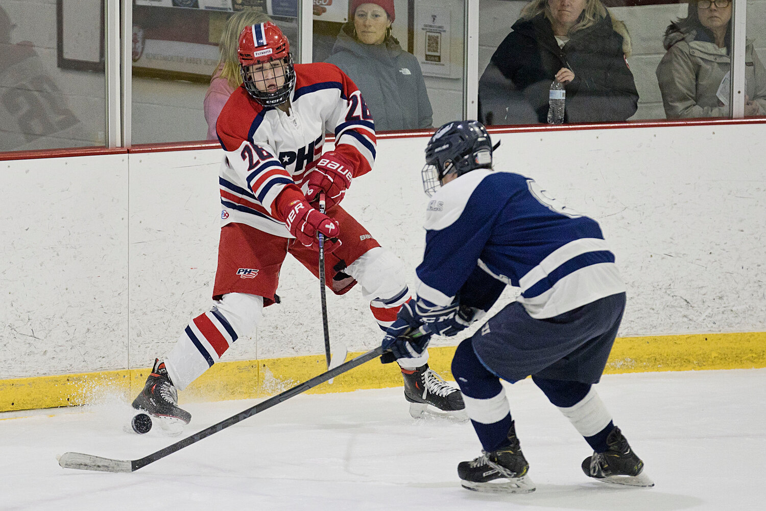 Hadrian Dougherty blocks a South Kingstown opponent from taking possession of the puck.