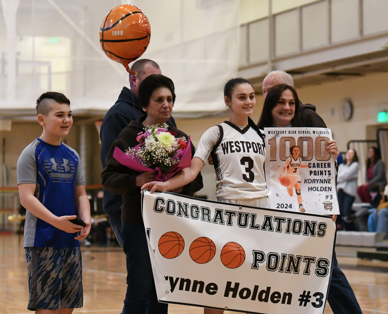 Korynne Holden celebrates with family after scoring her 1000th point on Friday night.