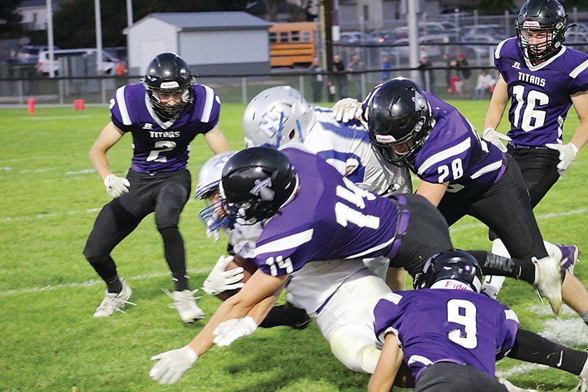 The Graettinger-Terril/Ruthven-Ayrshire defense converged on the ball carrier to make this stop against North Iowa last Friday. Titans pictures are Max Hough (2), Brody Simington (14), Nolan Darr (28), Eric Heinrichs (9), and Blake Rosacker (16).