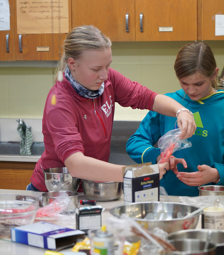 Megan Lausen and Candennce Vandehof work together at the Cupcake Challenge on Tuesday.
