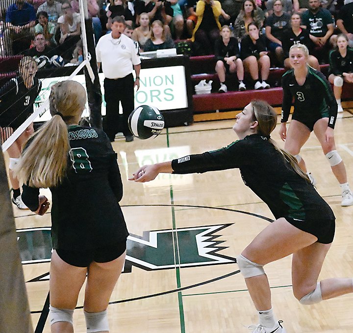Emily Meyer passes the ball to setter Libby Stevens during the first few points of the first game against Forest City.  Outside hitter Brylie Deim was ready to hit the ball.  Photo by Kim Meyer, Bancroft Register