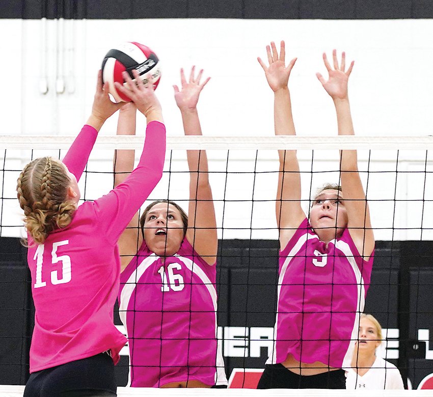 Estherville Lincoln Central seniors Emily Regelstad (16) and Audree Reinhardt (9) go up for a block during Tuesday&rsquo;s match against Storm Lake. Both teams were pink for &ldquo;Pink Out Night&rdquo; as funds were raised for Relay for Life.