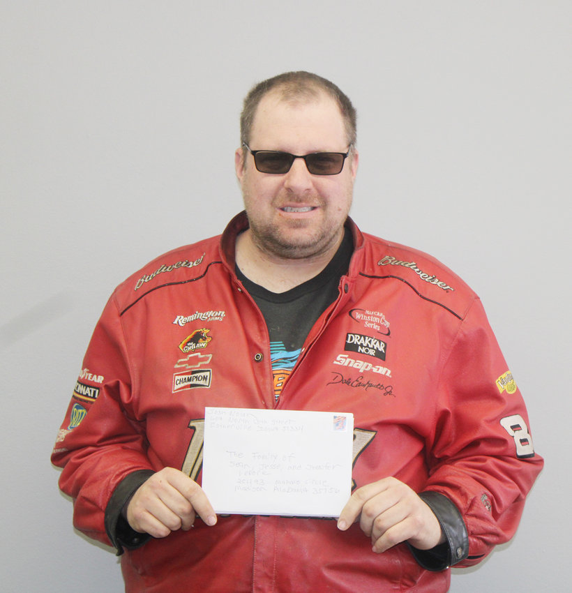 Josh Nolan, creator of the Full Throttle Racing Show #1, holds sympathy cards signed by community members and people in the racing community to uplift the family and loved ones of young racer Sean LePore, his brother Jesse, and his mother, Jennifer.     Photo by Amy H. Peterson