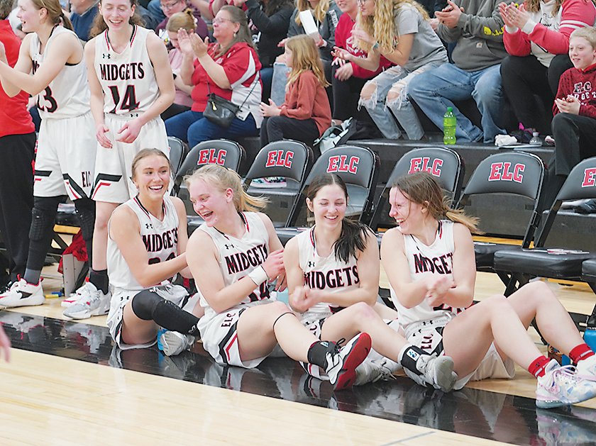 ELC&rsquo;s Haylee Stokes and Jordyn Stokes cheer after their teammates made basket while Rylee Yager, Hillary Ruschy, Cara Schiltz, and Jasey Anderson pantomime rowing a boat as the Midgets had already secured a victory over Algona in last Saturday&rsquo;s Class 3A Region final.  Photo by David Swartz