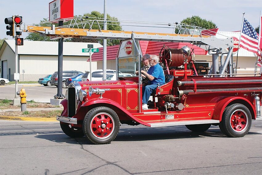 Alan Hanson and retired Estherville Fire Chief Lyle Hum drive the 1933 REO Speedwagon in a parade in Estherville.