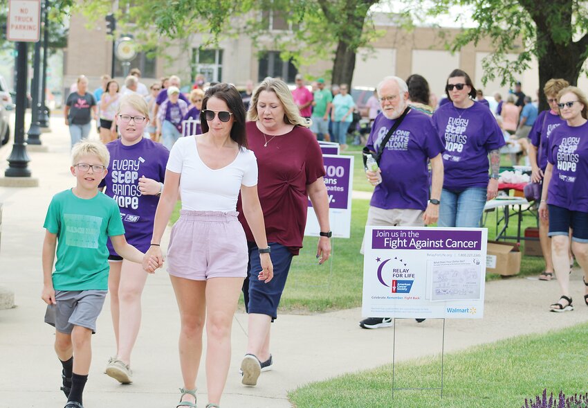 Dawson Sifrit, left, walks with his aunt, McKenzie Peta, right, along with fellow Survivor Kate Van Cleave, in purple, and Kate&rsquo;s grandmother Teresa Hoffman, as they led the survivor&rsquo;s lap.