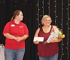 A delighted Janine Kinnander of Armstrong accepts the award for induction into the Iowa 4-H Hall of Fame last Thursday night. Katelyn Herzberg, left, presented the award to Kinnander, who said she was not expecting it at all.