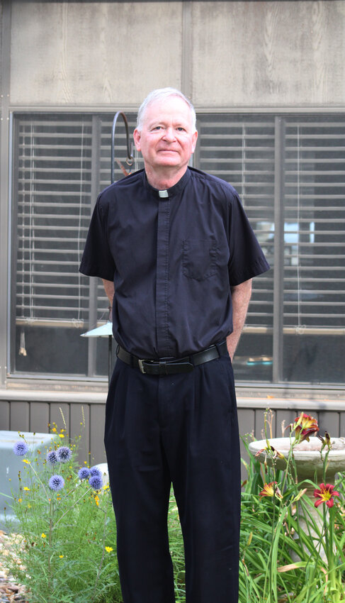 Father Paul Kelly took a moment of contemplation in his flower garden at St. Patrick&rsquo;s Catholic Church last week. These moments are becoming more rare as Father Kelly is now assigned to four local churches and Emmetsburg Catholic School.
