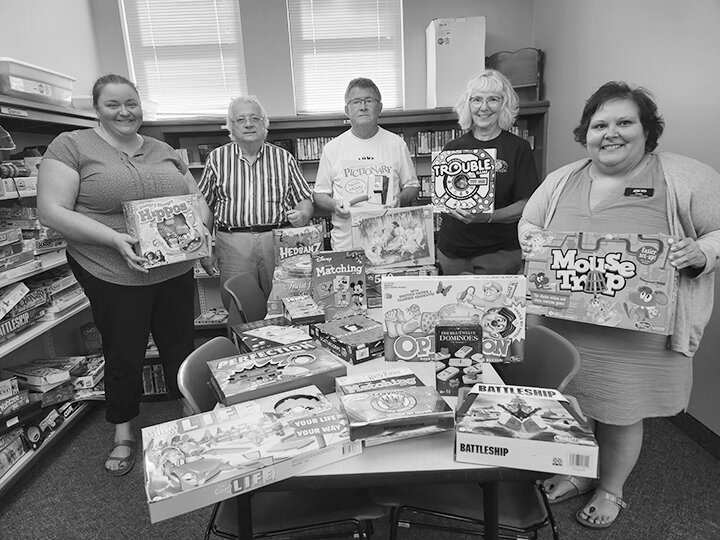 The Estherville North Star Kiwanis Group, affiliated with the Estherville Kiwanis Club, donated games and puzzles to the Estherville Public Library Tuesday, Aug. 22. From left are Kiwanians Jessica Carlson, treasurer; Michael Tidemann; President Dale Breuer; and Secretary Norma Beaver. At right is Children&rsquo;s Librarian Paula Spoo.