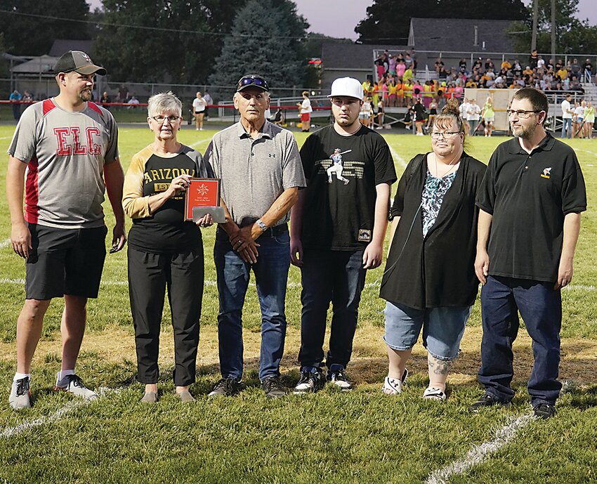 Estherville Lincoln Central Booster Club President Dean Gesche, left, presented Vicki and Galen Peta with the 2023-24 Fans of the Year award last Friday night. With the Petas are grandson Noah and daughter-in-law and son Tina and Todd Peta.
