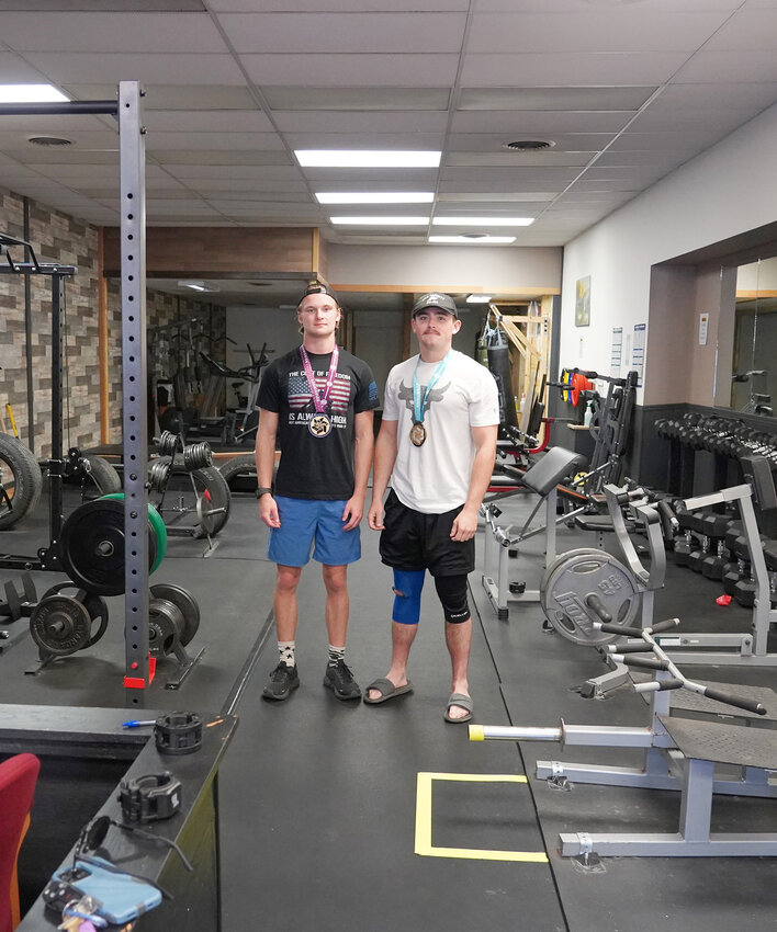 Will Martin and Justin Wolfe stand with their medals in the 362 Training Center in Estherville.
