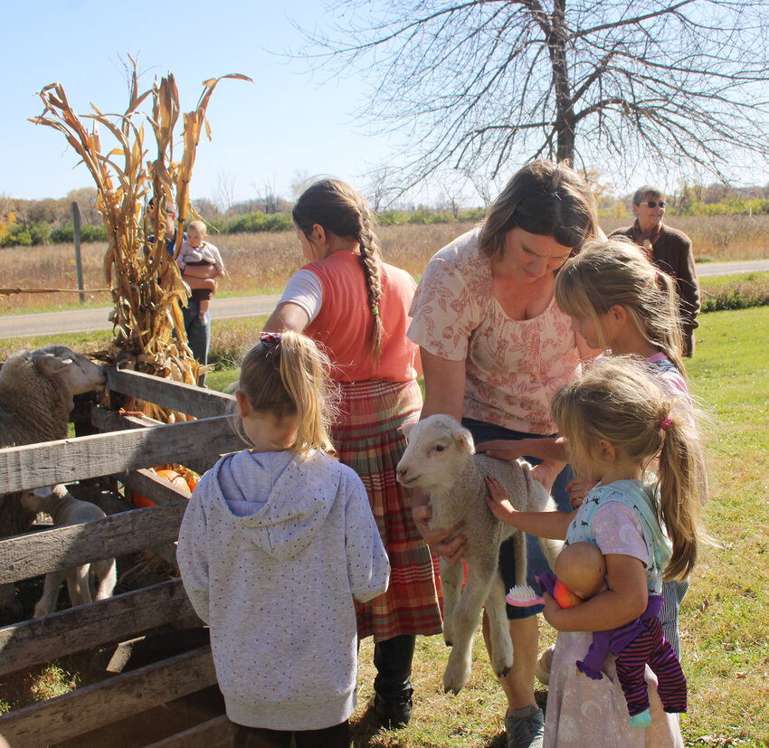 Anna Pickar, center, holds a lamb for animal lovers at the petting zoo at the Fall Festivall this past Saturday at the Brugjeld-Peterson Historic Farmstead