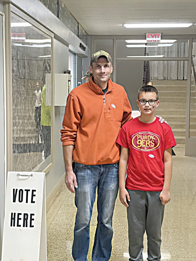 Kirk Radtke, left, voted in the city and school board election at the Emmet County Courthouse on Tuesday evening. Radtke brought son Huxley along.