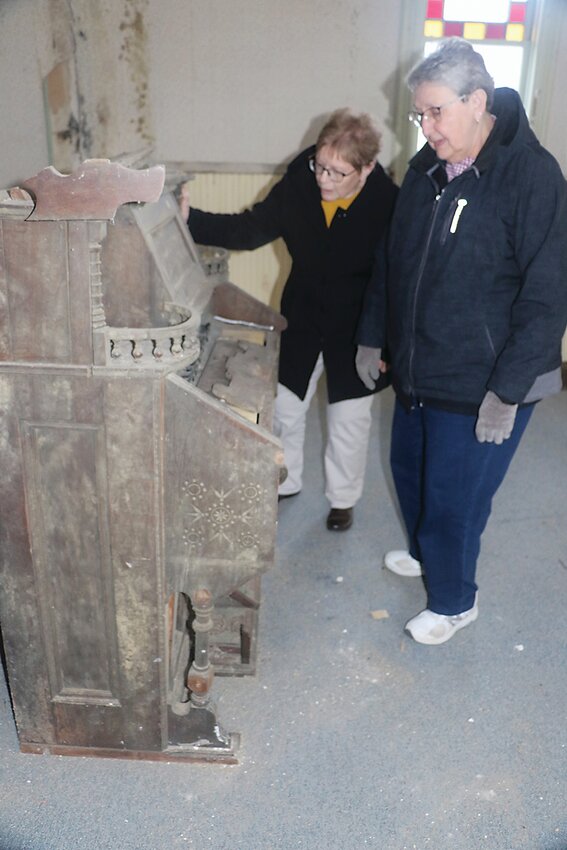 Athlyn Black and Marlys Nelson examine a pump organ that will be in the museum.