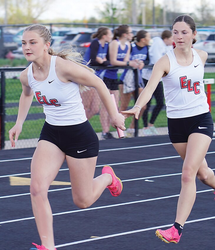 ELC’s Cara Schiltz hands off to Zoey DeRuyter in the first exchange of the sprint medley during last week’s state qualifying meet at Spirit Lake. The Midgets placed first in the event and will compete at state this week.