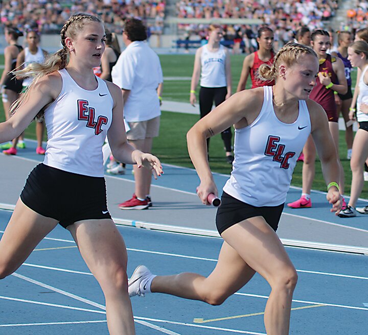ELC’s Tatum Dunlavy begins her leg of the sprint medley after taking the handoff from Zoey DeRuyter on Saturday.