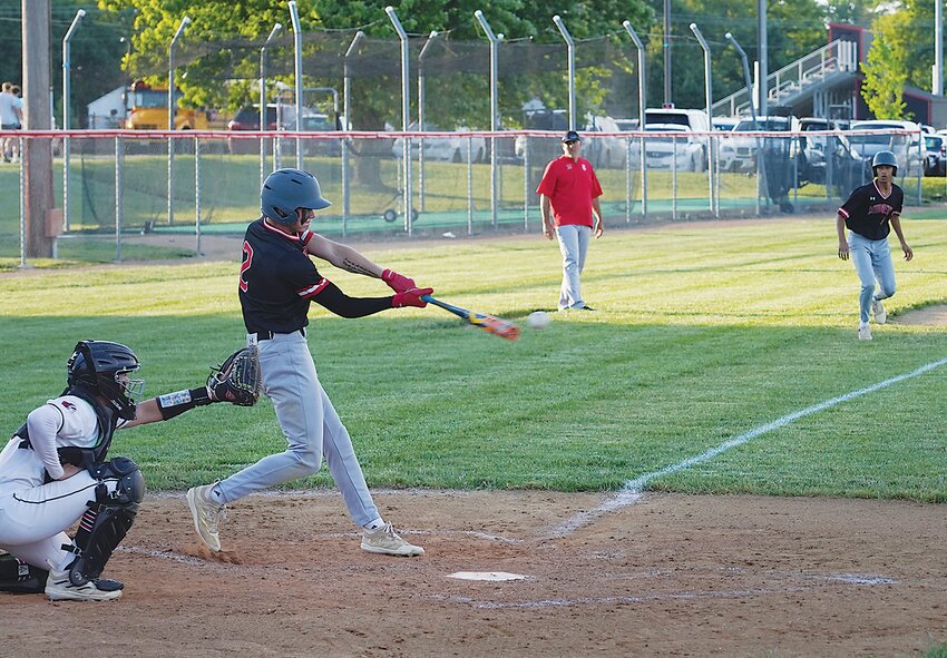 ELC courtesy runner Amari Armstrong looks to come home from third base as Aiden Swanson makes contact at the plate during Monday’s game in Spirit Lake. Swanson hit a double during this at-bat to bring Armstrong home.