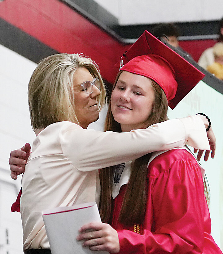 Tara Paul gives daughter Kennedy a hug during the graduation ceremony in May.