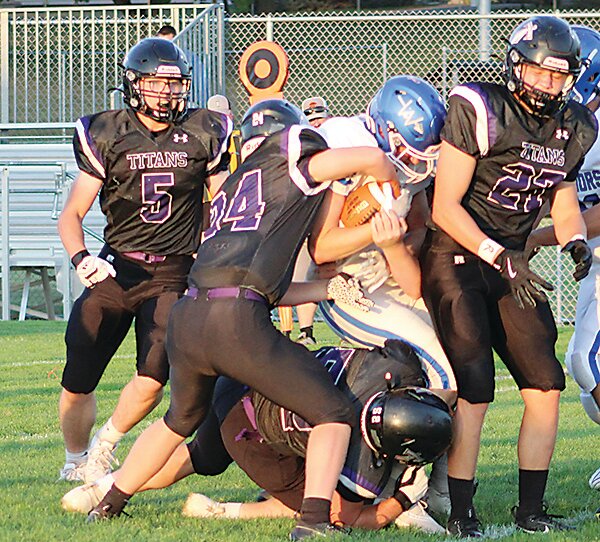 Isaiah Malm strips the ball as the Titan defense of Malm (24) Jon Krieger (5), Landon Dietrich (27) and Donovan Young at the ankles crashes through the line for the sack.