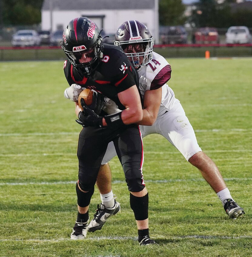 ELC’s James Richard drags an Okoboji defender across the goal line for the Midgets’ first touchdown on Friday. Richard scored two first-half rushing touchdowns in the game.