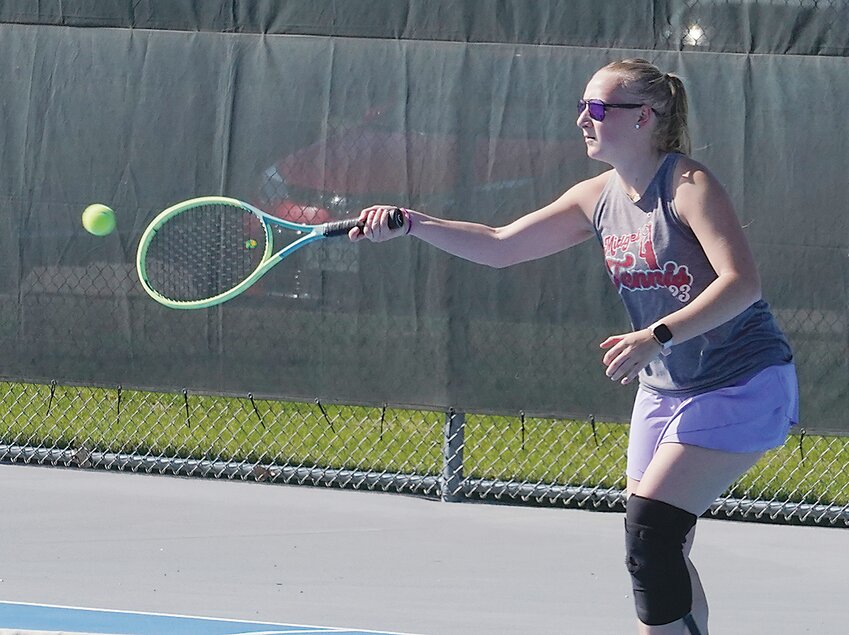 ELC junior Megan Lausen hits a return during a meet last week in Estherville. She earned Lakes Conference honorable mention at last week’s league meet.