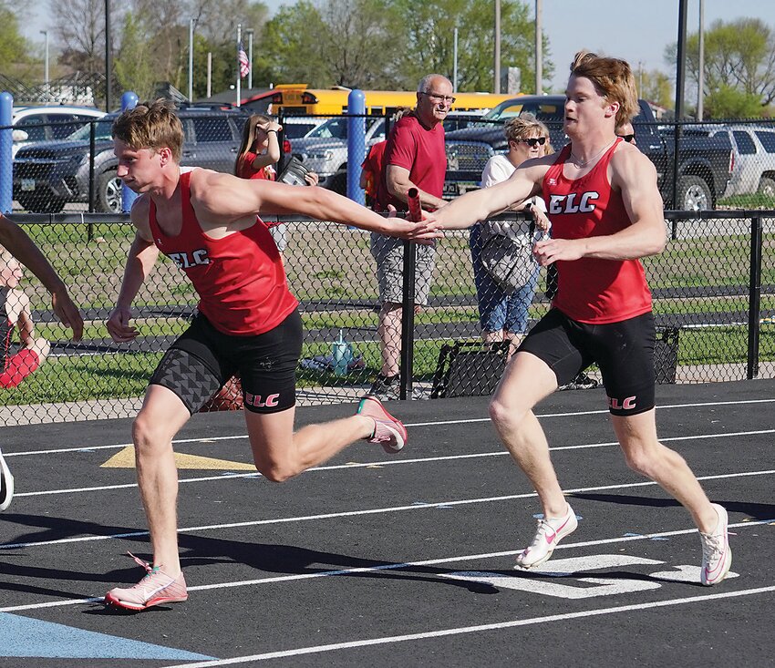ELC’s Wes Martin hands off to Tate White in the first exchange of the sprint medley relay last Thursday at the Lakes Conference Meet in Spirit Lake.