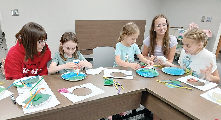 Sheila King with daughter Sydnie and Ava Stith, mother Dorothy and sister Emma worked on a project at the library under the direction of Emmet County Naturalist Sidney Krueger.
