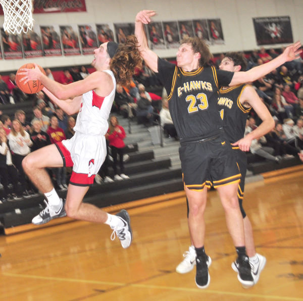 ELC’s Matt Christensen fools Emmetsburg defender Colby Weir (23) on taking the ball to the opposite side of the basket on this break-away layup in the fourth quarter last Thursday.
Photo by David Swartz