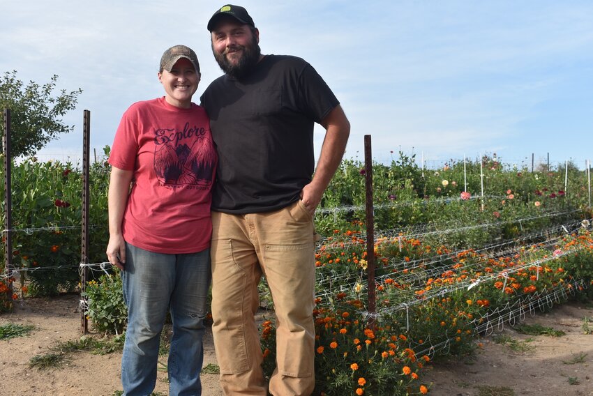 Tori and Trever Farrar pose in front of one of four dahlia beds on their property just outside of Hillsboro. The beds are part of the family’s recent business endeavor: The Dahlia Patch, a pick-your-own dahlia garden which is in its second year.