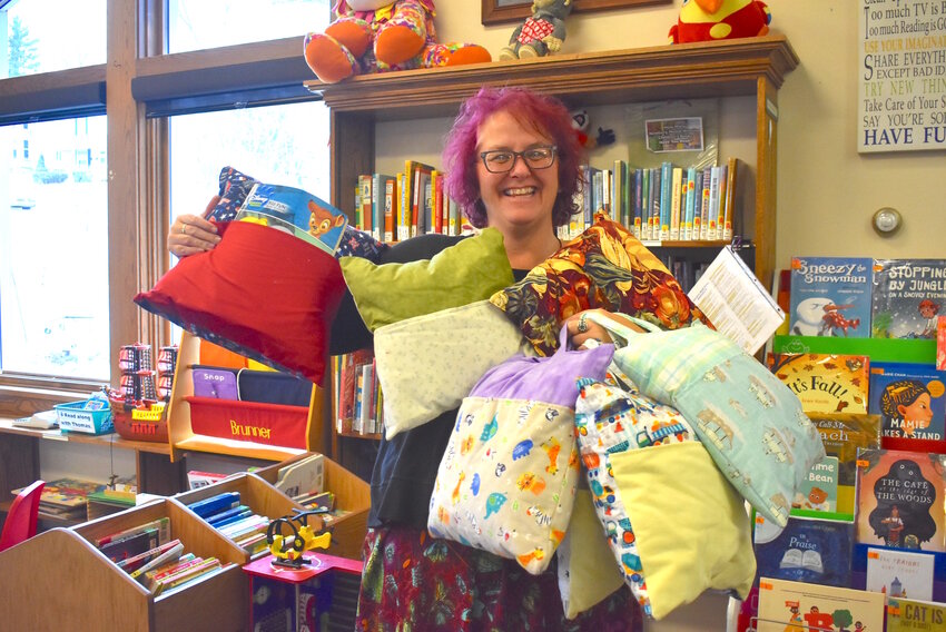 Kari Preuss, director for the Elroy Public Library, shows off a selection of handmade book pillows. The pillows were crafted by members of the Millard’s Prairie Home and Community Educators and are being sold to help raise money for future Carl Von Haden Community Service Award scholarships.