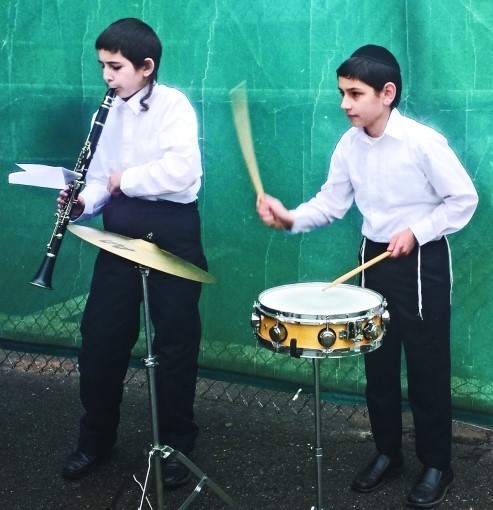 Shmuel Yehuda Schochet, right, plays the drums and Meir Mordechai Peromsik the clarinet as the PHDS Band performs the National Anthem at McCoy Stadium on April 12.