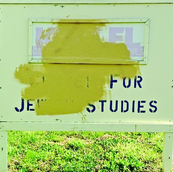 The sign with the vandalism obscured.