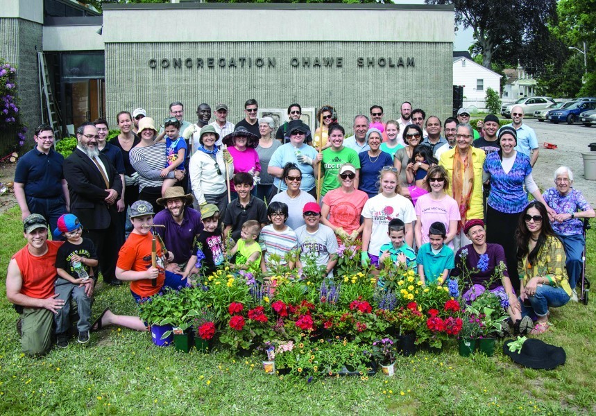 Participants in the beautification project at Ohawe Sholam gather for a group photo May 29. Approximately 50 people pitched in to help spruce up the outside of the Pawtucket shul, planting flowers and trimming bushes. More photos on page 18.