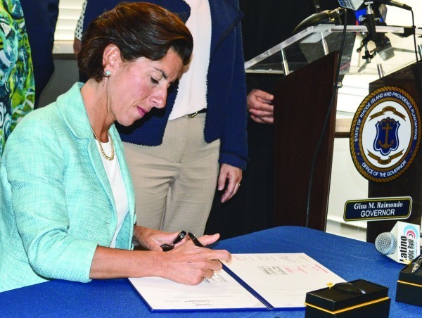 Governor Gina Raimondo signs the bill.