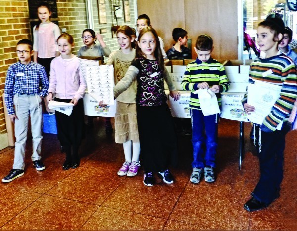 PHDS fourth-graders collect food donations from their schoolmates at the PHDS Thanksgiving assembly on Nov. 22.