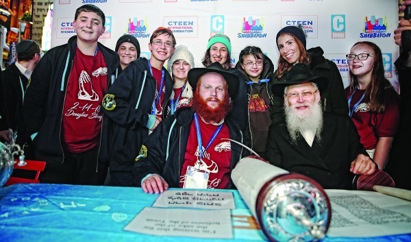 In center, with the red beard, Rabbi Shaya Denburg, co-director of CTeen in Coral Springs, Florida, with Rabbi Moshe Klein on his left;&nbsp;Chayale Denburg, co-director of CTeen in Coral Springs, standing second from right; and some survivors of the Parkland, Florida, school shooting. The survivors were in New York this weekend for Chabad&rsquo;s CTeen conference.