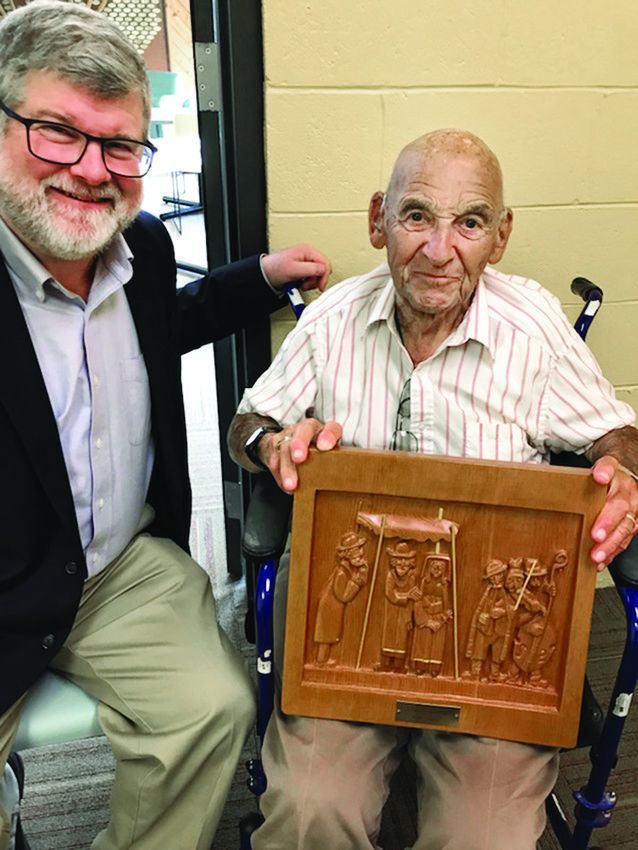 Rabbi Jeffrey Goldwasser with Sam Nelson who is holding his wood carving.