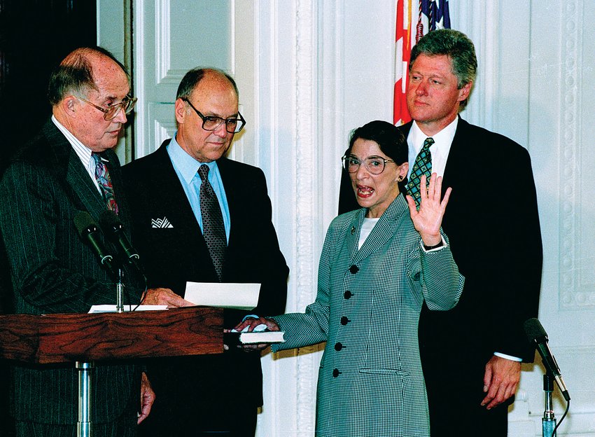 Chief Justice William H. Renquist administers the oath of office at the White House to incoming Justice Ruth Bader Ginsberg standing together with&nbsp;her husband&nbsp;Martin Ginsberg, holding the bible, and then President Bill Clinton. The White House, 1993.