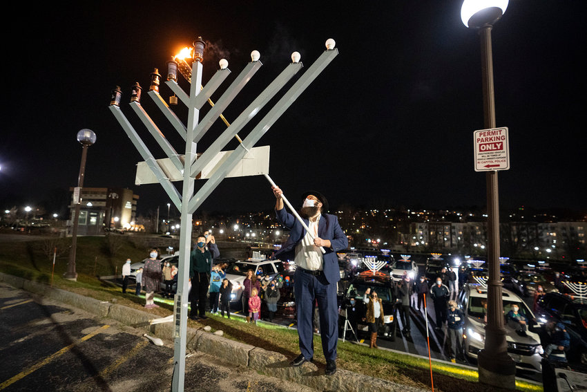 After a menorah car parade through Rhode Island on Dec. 13,  Rabbi Aryeh Laufer lights the menorah set up outside the Rhode Island State House.