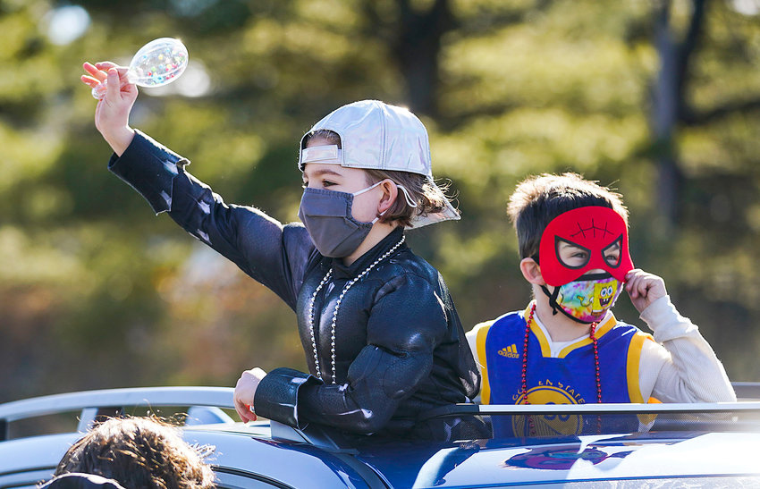 Micah Bogad, 9, left, and Noah Holt, 6, right, both of Providence, poke through the sun roof with a mask and a maraca they received at the event.