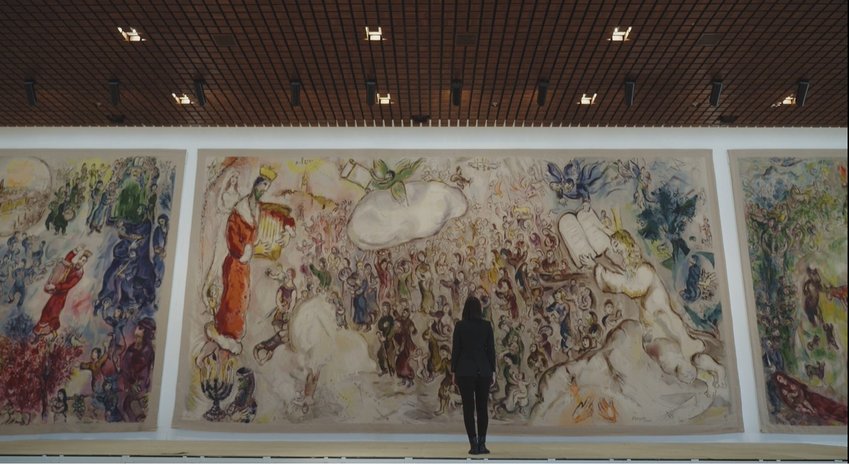 As part of Beit Avi Chai's online offerings, Israeli journalist Romy Neumark, center, narrates a series of short films on artistic works that bring Jewish holidays to light, including this painting by Marc Chagall at Israel's Knesset.