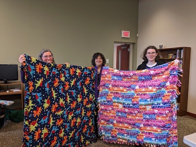 Project Linus Mitzvah Day participants display some of their quilts.
