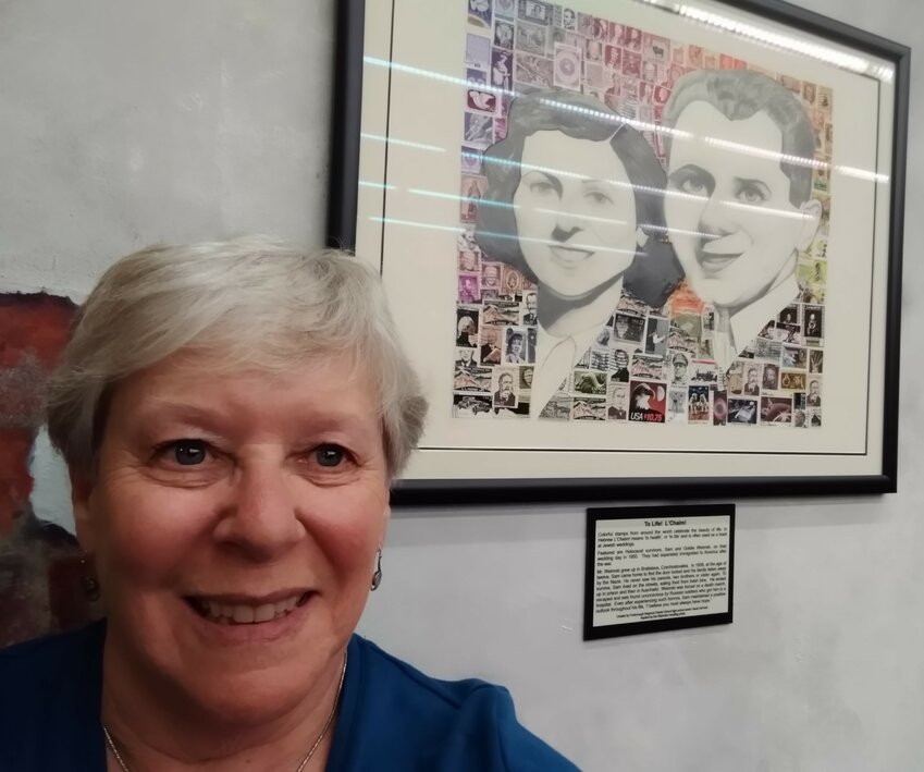 Charlotte Sheer took this selfie in front of one of the 18 collages made from some of the 11 million stamps collected as part of the Holocaust Stamps Project that&rsquo;s part of the exhibit at the American Philatelic Center called &ldquo;A Philatelic Memorial of the Holocaust.&rdquo; &ldquo;L&rsquo;Chaim &ndash; To Life!&rdquo; celebrates Holocaust survivors Sam and Goldie Weinreb.