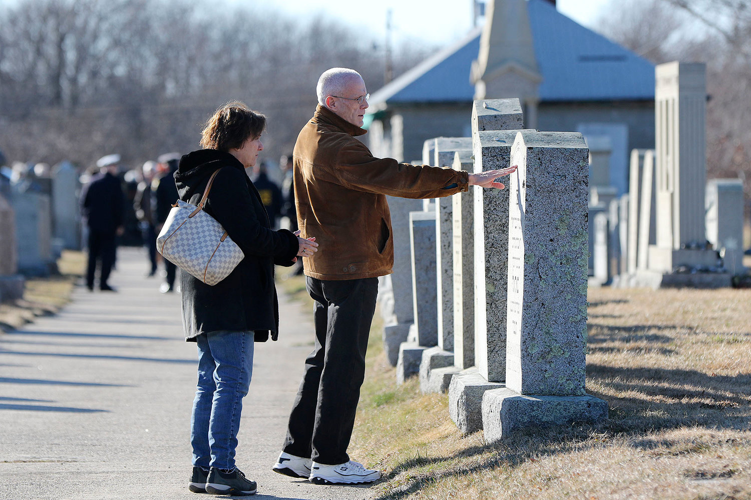 Cathy Horvitz, of Westwood, MA, left, and Ken Rapisa, of Fall River, right, look over the grave stones in the cemetery.   They did not know each other before this day.