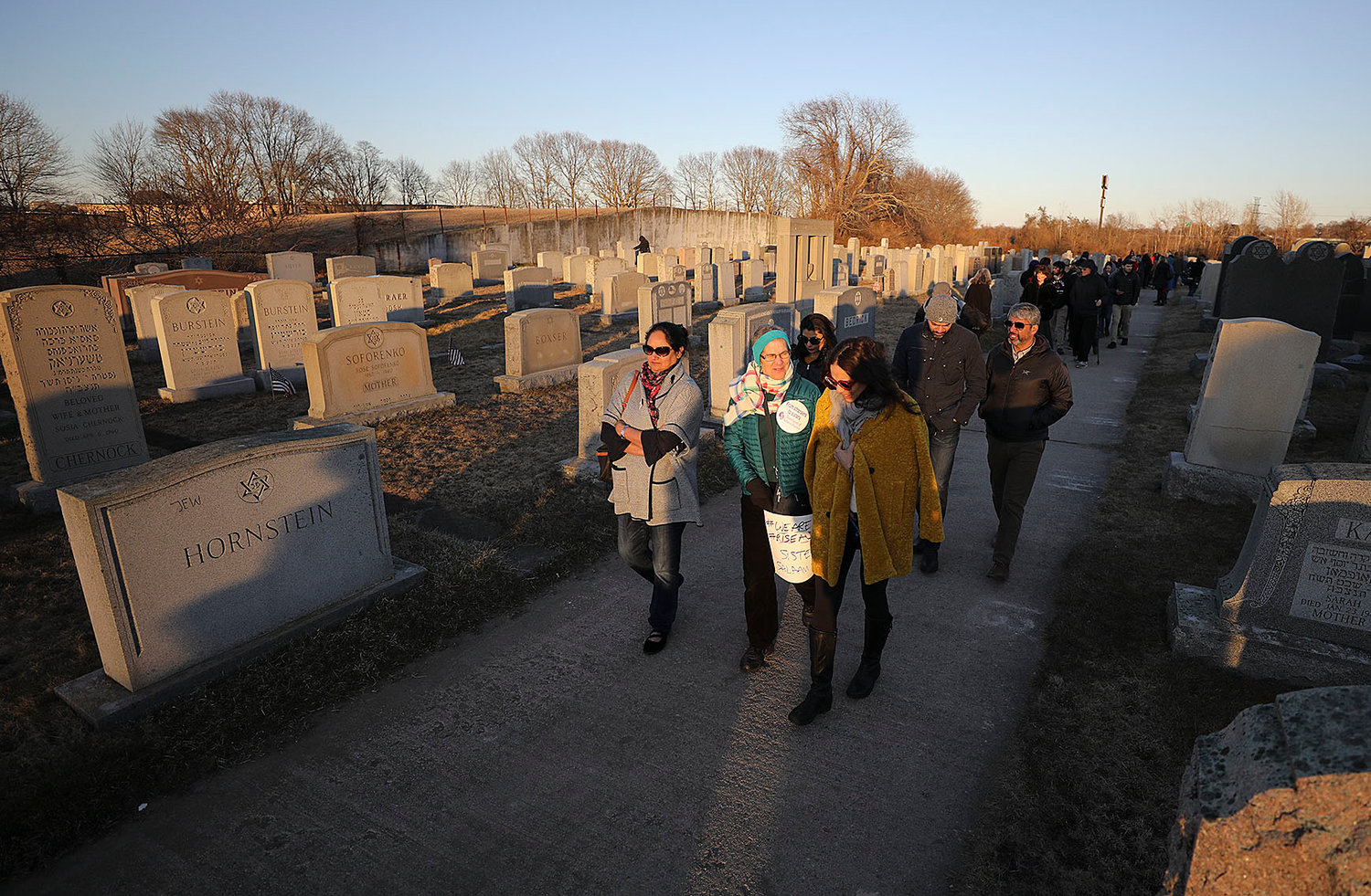 People walk through the cemetery after the ceremony.