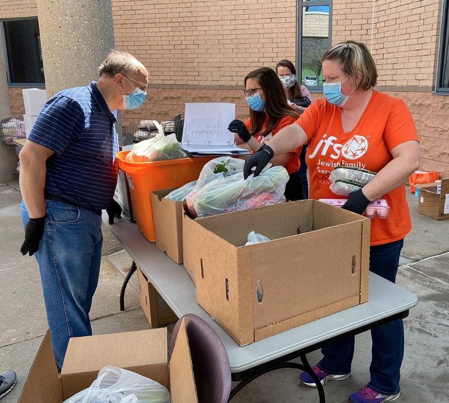 Food pantry volunteers work outside at the Jewish Federation of Kansas City amid the adoption of new pandemic-era health-and-safety protocols by Jewish institutions around the country.