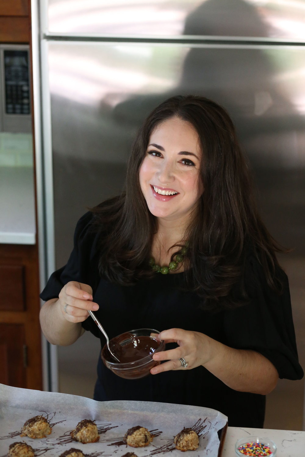 Sarna drizzles melted chocolate over coconut macaroons, one of the sweet recipes in her book.